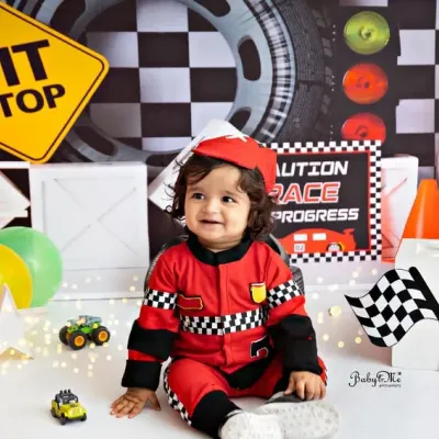 This little racer is all smiles and ready for his first birthday pit stop. The detailed race car set, complete with a Lightning McQueen cutout, is perfect for capturing high-energy portraits.