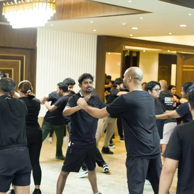 Students pair up during a Practitioner Level camp to drill defenses against common attacks. These sessions are crucial for building the reflexes needed to respond effectively under stress.