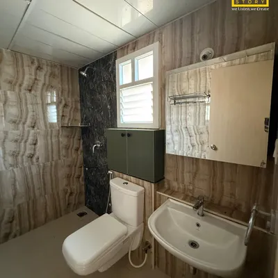 This modern bathroom features walls clad in onyx-patterned tiles, creating a luxurious and dramatic effect. The wall-mounted cabinet and minimalist sink complete the clean, contemporary look.