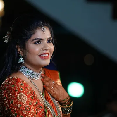 A radiant bride on her wedding day. I designed this heavily embroidered orange and green blouse to perfectly complement her rich silk saree.