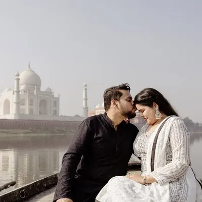 A serene and romantic portrait on a boat, with the Taj Mahal creating a breathtaking backdrop. This angle offers a unique and peaceful perspective, away from the crowds.