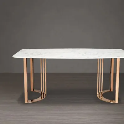 This make-to-order dining table features a white marble top and a striking rose gold metal base. It's a luxurious centerpiece for any modern dining room.