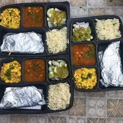 A set of my standard vegetarian thalis ready for delivery. This meal included Paneer Bhurji, Chana Masala, fresh salad with green chutney, fluffy rice, and foil-wrapped rotis to keep them soft.