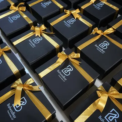 A fleet of our signature black and gold gift boxes, custom branded for Balwadkar Associates. This is how we execute large orders with a consistent, premium, and elegant finish.