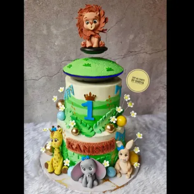 This two-tier jungle adventure cake was for a wild first birthday. It features a floating top tier and adorable, handmade fondant animals like a giraffe, elephant, and lion, creating a playful safari scene.