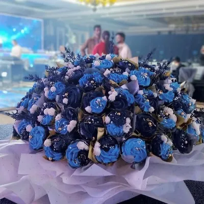 A massive 100-cupcake bouquet created for a corporate event. The cupcakes are decorated in shades of blue and white, creating a stunning and delicious centerpiece.
