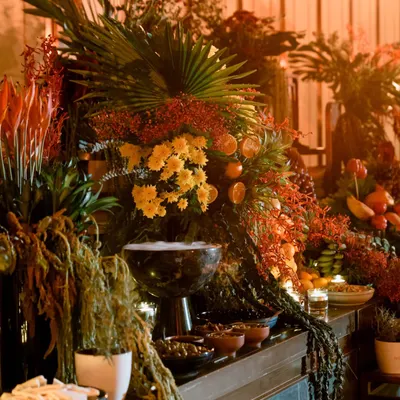 The goal is to create a scene of overwhelming beauty. This section of the grazing table shows how I use large palm fronds and dense floral arrangements to build height and drama, making the food display feel like a lush, tropical oasis.