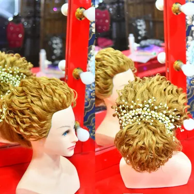 This is an example of the intricate updos we practice in our professional hairstyling classes. This style features detailed curls and is finished with delicate baby's breath flowers.