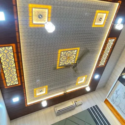 Yeh hamara ek popular ceiling design hai. Ismein light-coloured PVC panels ke saath wooden borders, backlit jaali work, aur integrated lighting ka istemaal hua hai. Poora package ek hi design mein.