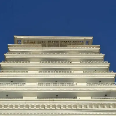 The classic architectural facade of Soho House, Mumbai. We designed this hospitality marvel to be a timeless white structure by the sea, using finely crafted cornices, cast iron grills, and archways to create a sense of regal character and warmth.