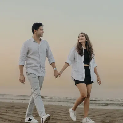 A classic pre-wedding beach photo. Walking hand-in-hand along the shore as the sun sets, this is a timeless portrait of togetherness and the start of a new journey.
