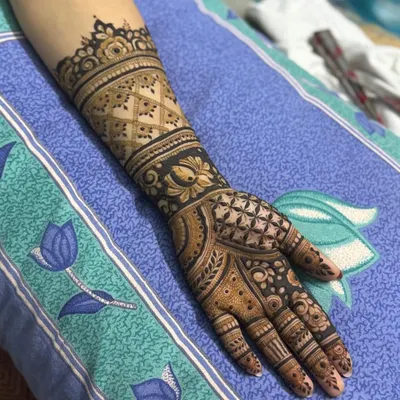 This design features a prominent 'jaal' or grid pattern on the forearm, balanced with a beautiful floral-geometric pattern on the palm.