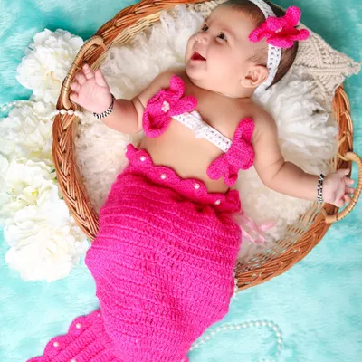 A dreamy mermaid-themed shoot for this happy baby. The hand-knitted pink mermaid tail and matching top create an adorable underwater fantasy.
