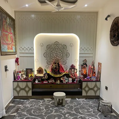 A recently completed Mandir design. The backdrop features a CNC-cut panel with an Om and mandala motif, which is backlit to create a serene and divine glow.