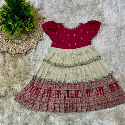 A custom-designed tiered frock for a little girl, using traditional printed fabric for the skirt and a simple magenta top.