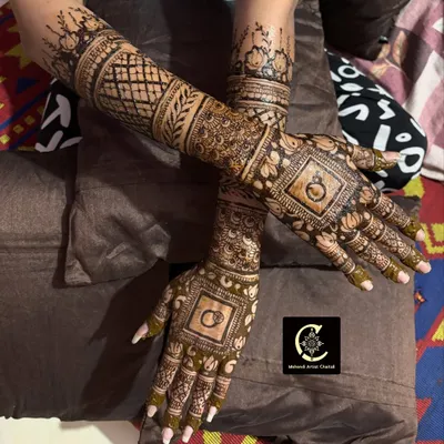 A classic engagement mehendi design featuring interlocking rings, a symbol of your commitment. The rest of the hands are filled with detailed traditional patterns.