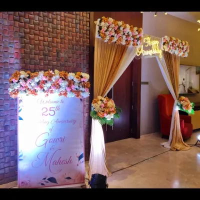 This welcome area for a 25th anniversary sets a graceful tone for the event. It includes a personalized, illuminated welcome board and a matching floral and draped entrance arch.