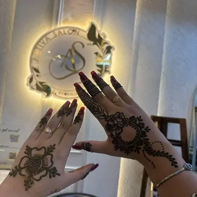 This photo shows two different mehendi styles perfect for an occasion like Rakhi. One hand features a delicate floral design on the back, while the other has a more intricate mandala and vine pattern, showing the variety I offer.