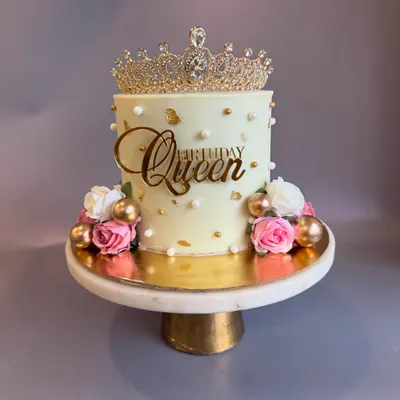 A cake that screams elegance and royalty, fit for a queen on her 40th birthday. This design features a beautiful crown topper, gold accents, and delicate roses.