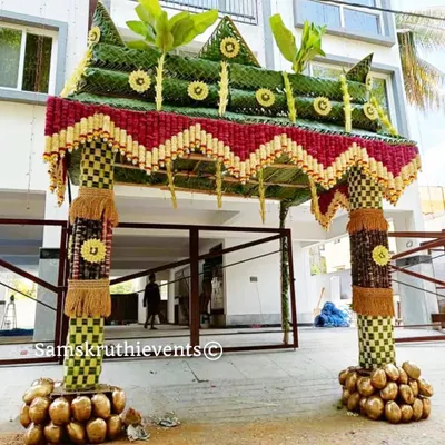 A magnificent 'Chappara' for a housewarming ceremony, made from woven coconut leaves and decorated with flowers. The base of the pillars is adorned with coconuts, symbolizing prosperity and new beginnings.