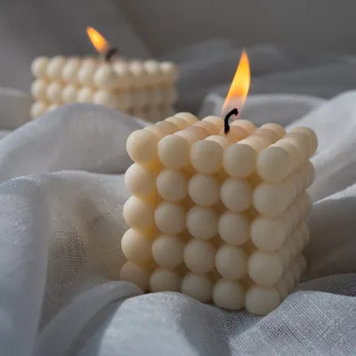 Our classic bubble candle, lit and glowing. The unique shape creates a beautiful play of light and shadow, making it a captivating decor piece.