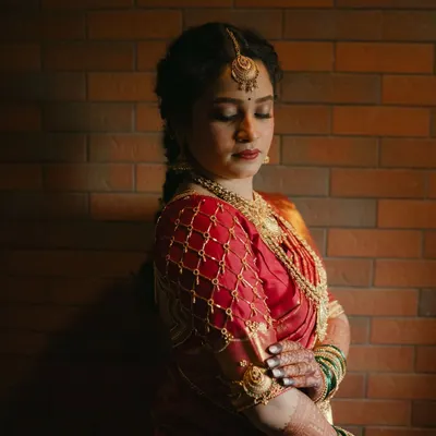 A classic South Indian bridal transformation. This portrait captures the regal feel, with a soft matte base, defined eyes, and a rich red lip to complement her silk saree.