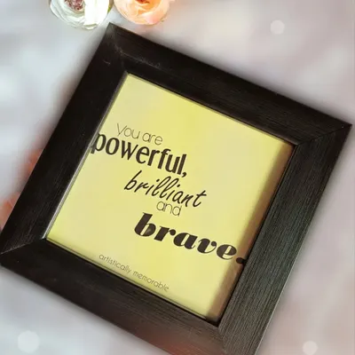 A mini quote frame with the empowering message, "You are powerful, brilliant and brave." This piece, set in a dark frame, is perfect for adding positivity to any workspace.