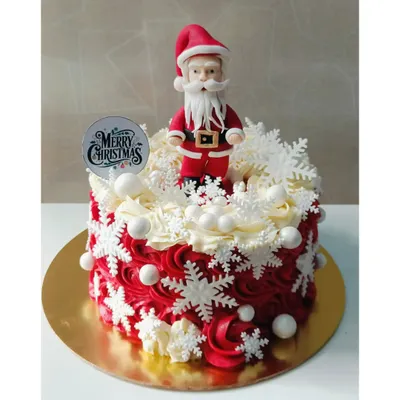 A truly festive Christmas cake, decorated with red and white buttercream swirls, delicate snowflakes, and a handmade Santa Claus topper. This makes a wonderful centerpiece for any holiday table.