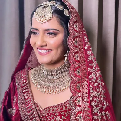 My beautiful bride ready for her Phera ceremony. She is wearing a traditional red velvet lehenga, and I created a classic bridal look with soft pink eyeshadow and a radiant base to match.