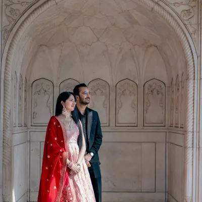 Standing within the intricate marble archways of a historic monument, this portrait feels both grand and personal. It’s a perfect example of a destination photoshoot that honors India's heritage.