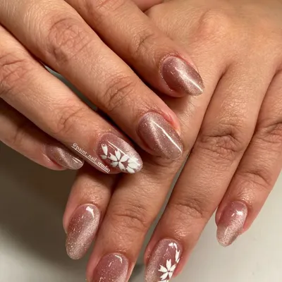 Proof that short nails can be incredibly pretty. This design features a shimmery cat-eye gel polish with a delicate, hand-painted white snowflake accent.
