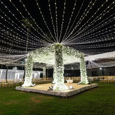 A wide view of our signature baby's breath octagon mandap, set under a universe of fairy lights. This design showcases our ability to transform a large outdoor lawn into a breathtaking, magical space for a wedding ceremony.