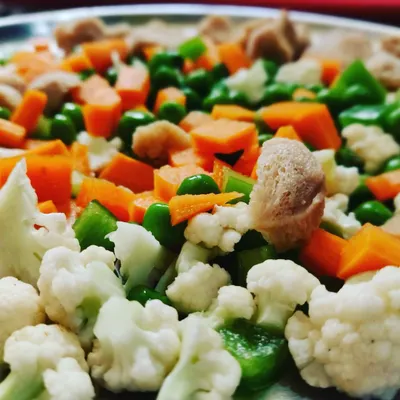 A colorful mix of fresh vegetables like carrots, peas, cauliflower, and soya chunks, ready to be made into Maharaja Poha.
