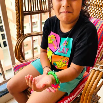 The pure joy on a child's face when she sees her new bangle! This piece is designed to be colorful, fun, and safe for kids to wear.