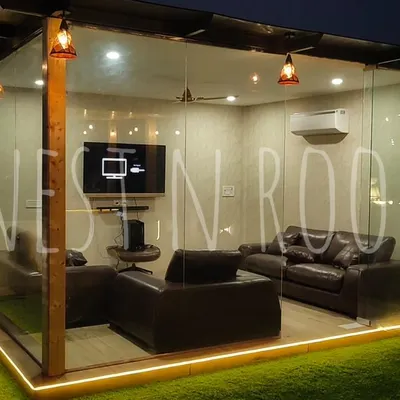 Our signature glass room, illuminated at night. These structures are built with toughened glass and a sturdy mild steel frame, providing a weatherproof, air-conditioned space that feels open and connected to the sky.