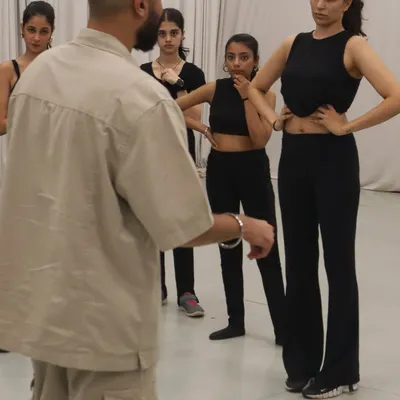 A close-up of a teaching moment where students are focused and engaged. I ensure everyone understands the details of the choreography before we move on.