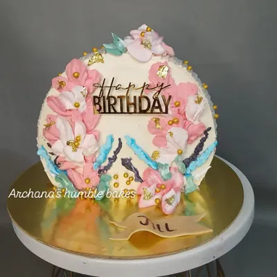 A beautiful birthday cake with a painted floral design made with buttercream.
