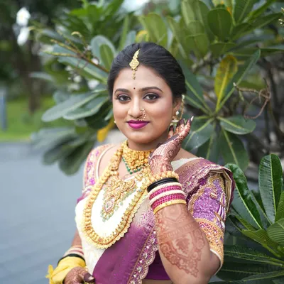 A beautiful portrait of Pooja on her wedding day. Her traditional South Indian bridal look features a classic updo, gold jewelry, and radiant makeup that enhances her natural glow.