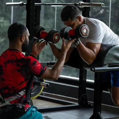 Perfecting your form is key to getting stronger and avoiding injury. I provide hands-on spotting and guidance for every exercise, like this dumbbell curl, to ensure you get the most out of every rep safely.
