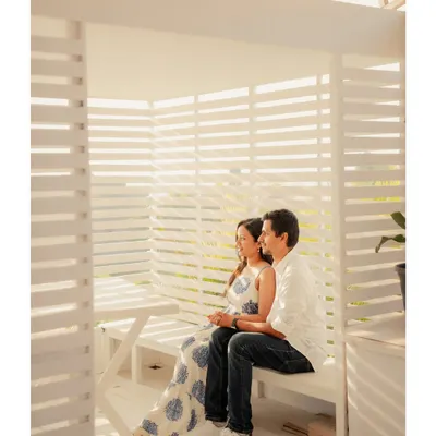 Annalisa and John in a bright, white cabana. The slatted walls create beautiful light and shadow patterns, adding geometric interest to this modern couple portrait.