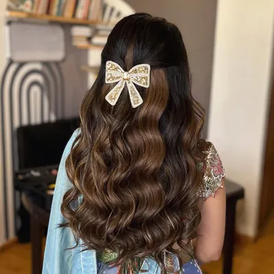When in doubt, put a bow on it. This beautiful, embellished bow is the centerpiece of this half updo with soft waves, creating a look that is both sweet and sophisticated for a Roka ceremony.