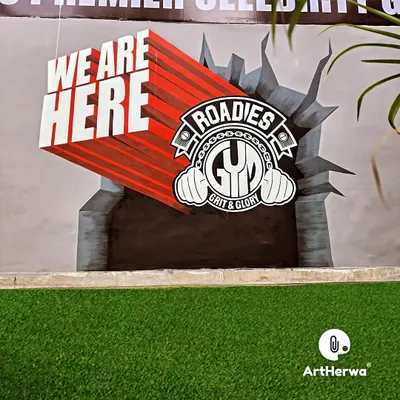 A powerful 3D mural for Roadies Gym, featuring their logo bursting through a wall. The "WE ARE HERE" text uses forced perspective to create a dynamic, eye-catching effect.