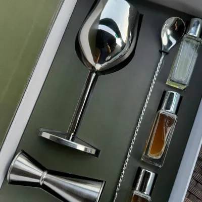 The complete One8 cocktail edition PR box. This curated set includes a stainless steel wine goblet, jigger, bar spoon, and a selection of artisanal cocktail mixers, designed to create an exclusive experience for recipients.