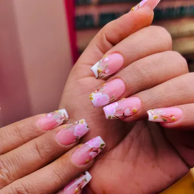 A classic pink and white French manicure gets a beautiful upgrade with delicate, hand-painted pink flowers and gold leaf accents. This is elegance in full bloom.