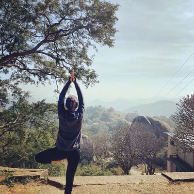Holding Vrikshasana, or Tree Pose, in a quiet outdoor space. This image is a reminder that it's okay not to have everything figured out. Recovery and growth are not linear, and it's important to give yourself the same love and gentleness you offer to others.