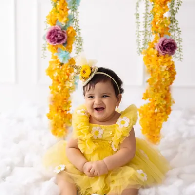 The happiest birthday girl! Her infectious laugh is the centerpiece of this sunny, floral-themed first birthday photoshoot.