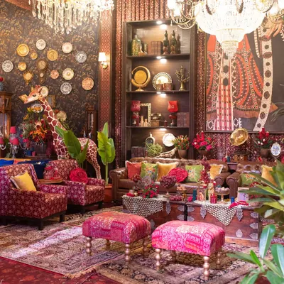 I designed this lounge to feel like a hidden gem. A rich tapestry of textures and patterns, from the leather Chesterfield sofa to the patterned rugs and a wall of curated plates, creates a maximalist yet cohesive look.
