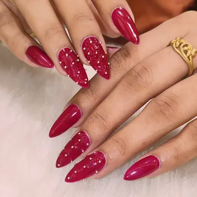 These nails are not for the faint of heart. This fierce stiletto set features a glossy, deep red color with accent nails that have a textured, beaded design for a look that's both dangerous and beautiful.