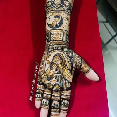 A complete baby shower mehendi design. The palm features a loving portrait of a mother holding her baby, while the arm has a "Coming Soon" message and a cute baby in a crescent moon.