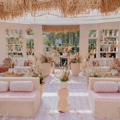 A wide view of the 'Desert Oasis' setup, showing the symmetrical arrangement of the baithak seating and the open, airy feel created by the high ceilings and window-like shelf structures.